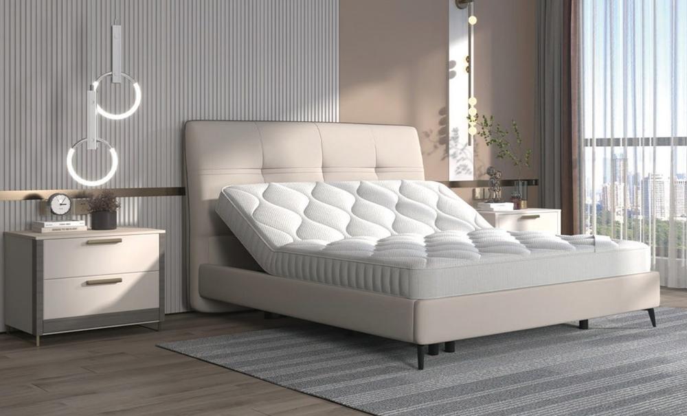 Ivory upholstered bed with a tufted headboard and the head of the mattress raised