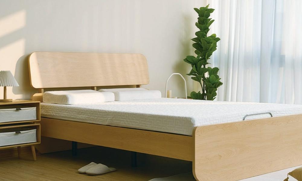 Light oak bed with a curved headboard and a raised mattress