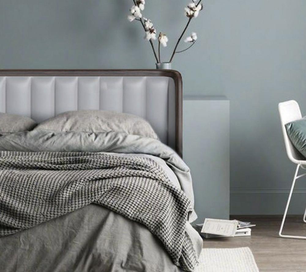 Grey bed with a wraparound walnut-framed headboard